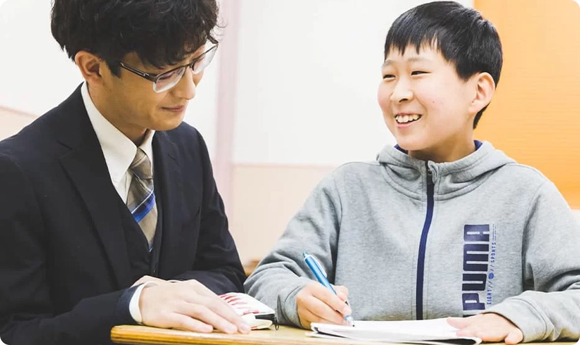 講師と笑顔で勉強する男子生徒の様子